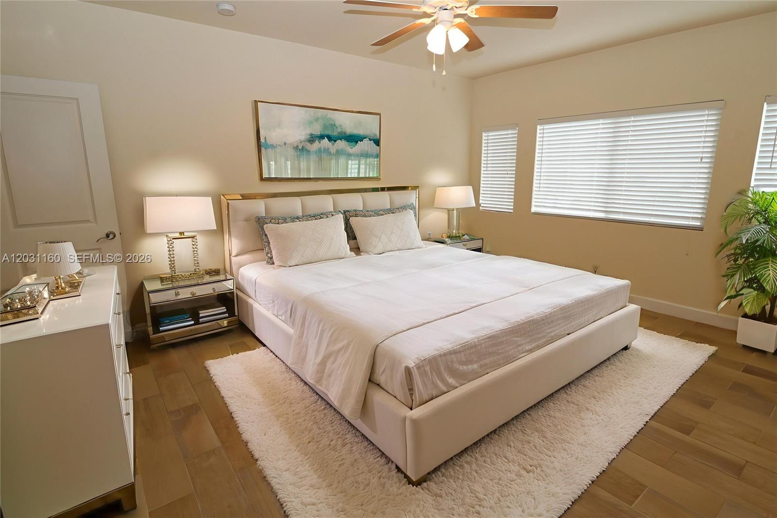 A bedroom features a white upholstered bed, mirrored nightstands, and a white area rug — 609 NE 28th St # 1, Wilton Manors FL 33334, WILTON MANORS, FL