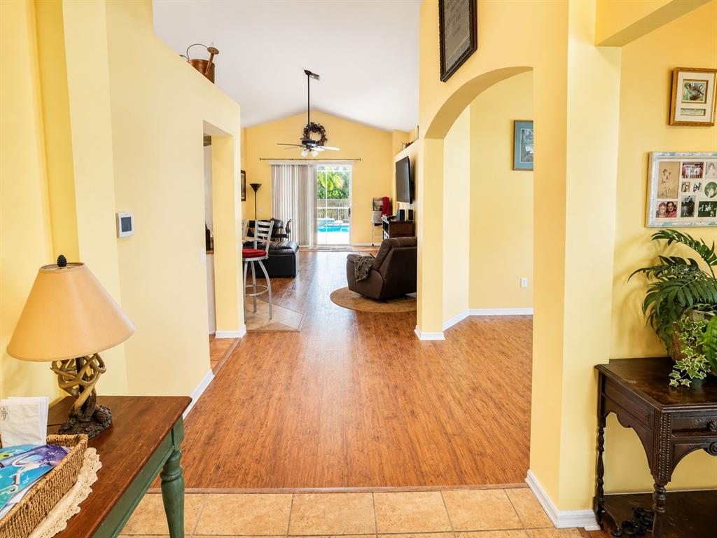 An entryway features tile flooring, a red rug, a console table, and a front door — 4431 STONES RIVER COURT, NEW PORT RICHEY, FL