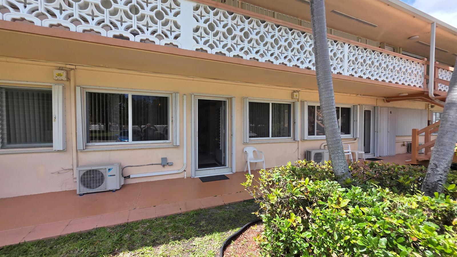 The exterior of a peach-colored apartment building features a white decorative screen and windows — 900 SW 10th Terrace # 2s, Hallandale Beach FL 33009, HALLANDALE BEACH, FL