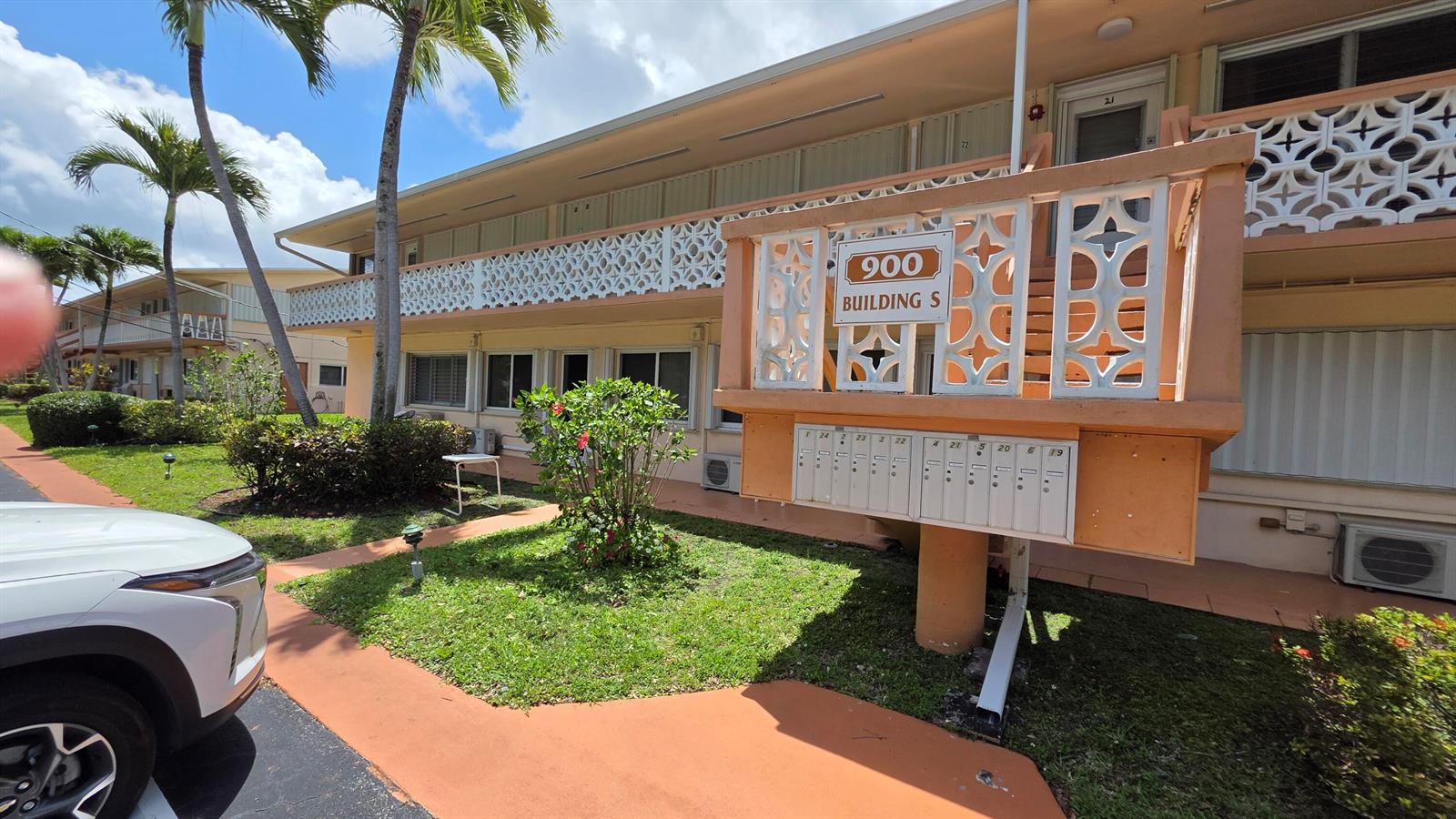 An exterior view of a two-story apartment building with a central mailbox unit — 900 SW 10th Terrace # 2s, Hallandale Beach FL 33009, HALLANDALE BEACH, FL