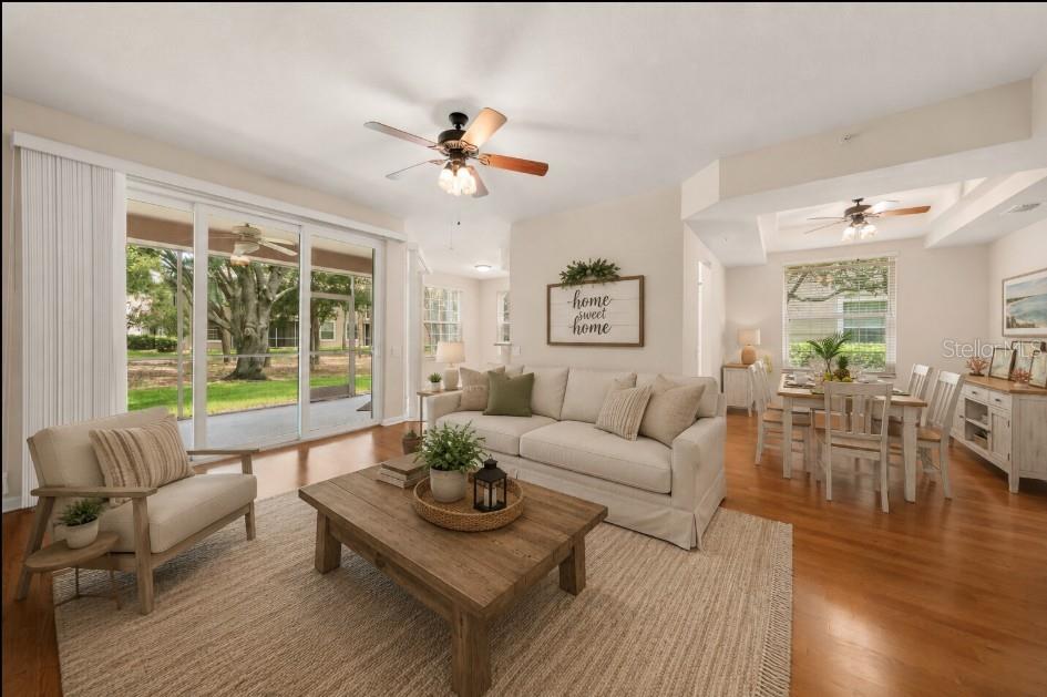 A living and dining room with hardwood floors, a beige sofa, and a wooden table — 853 LANTERN WAY, CLEARWATER, FL