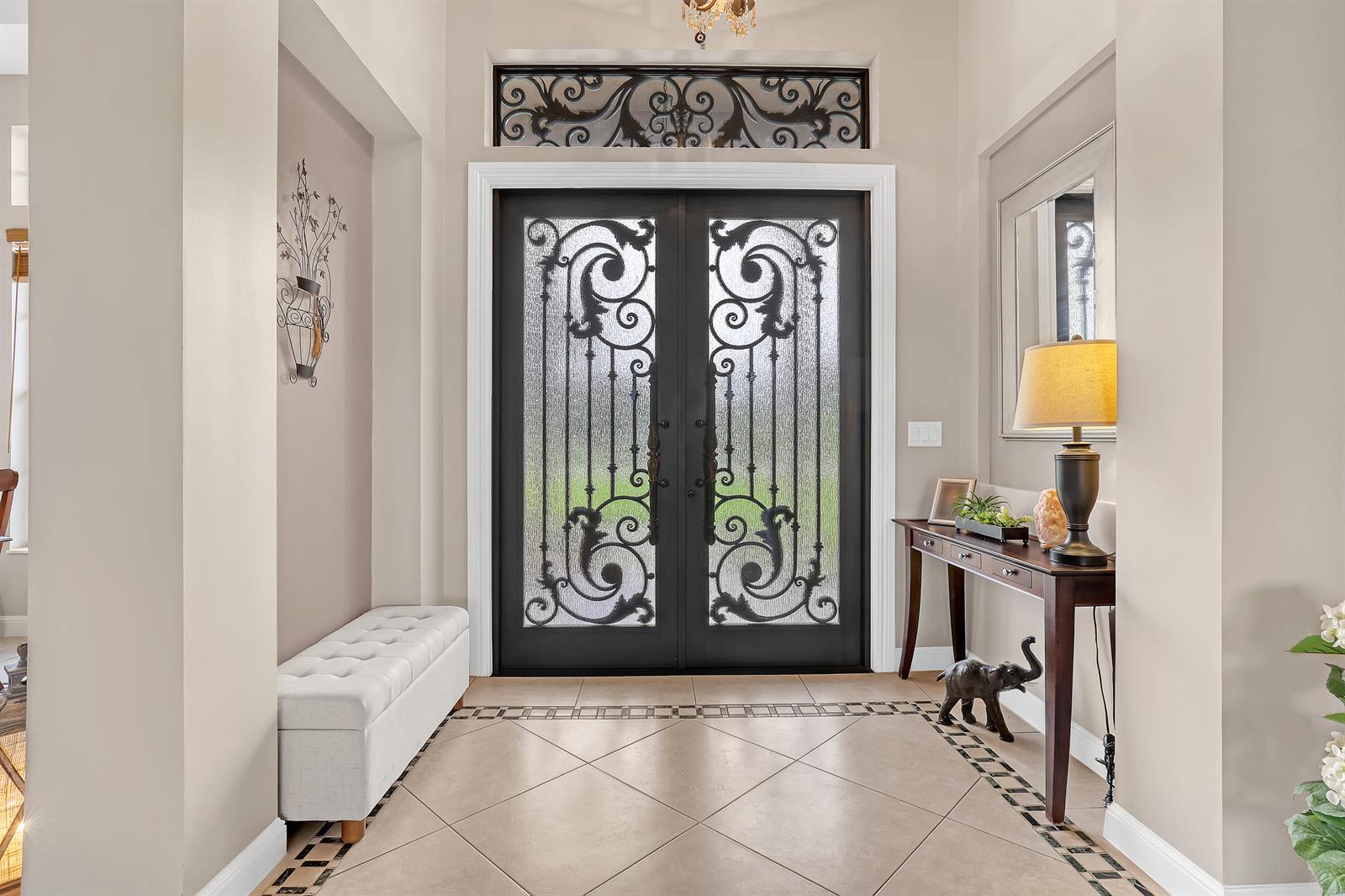An entryway features a double iron door with glass inserts, tile flooring, and a console table — 14042 88th Place N, FL 33470, FL