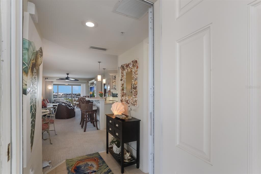 An entryway opens into a living area with a kitchen island and a coastal view — 5856 GASPARILLA ROAD UNIT M31, BOCA GRANDE, FL