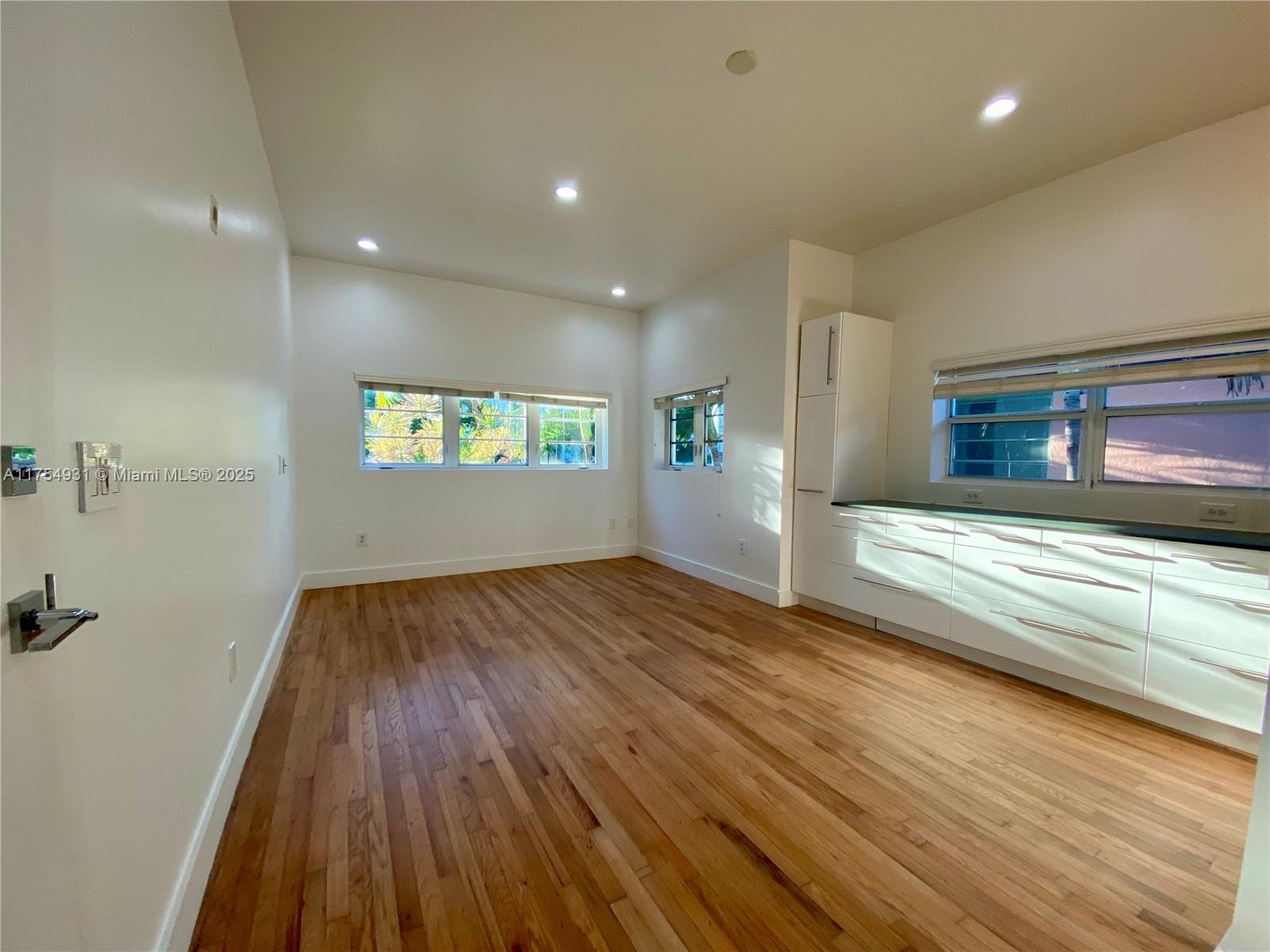 A bright room features hardwood floors, white walls, recessed lighting, and a modern kitchenette — 929 Michigan Ave # 5, Miami Beach FL 33139, MIAMI BEACH, FL