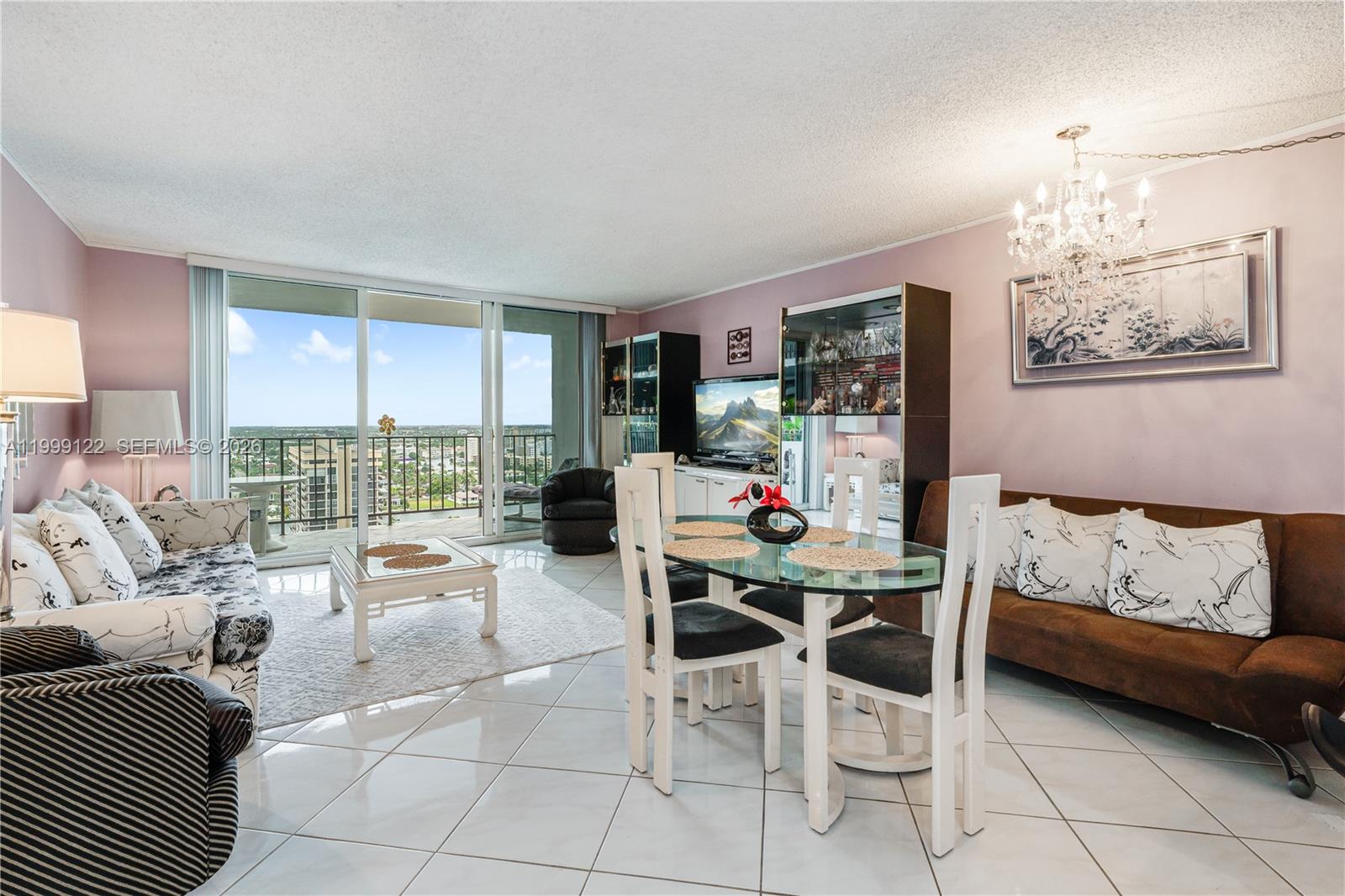 A living and dining area features tile floors, a glass table, and a balcony view — 2030 S Ocean Dr # 1903, Hallandale Beach FL 33009, HALLANDALE BEACH, FL