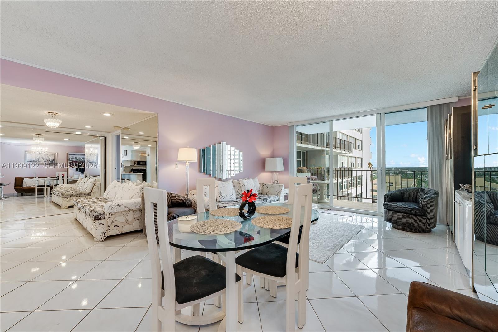 A dining area and living room feature white tile floors, lavender walls, and a balcony — 2030 S Ocean Dr # 1903, Hallandale Beach FL 33009, HALLANDALE BEACH, FL