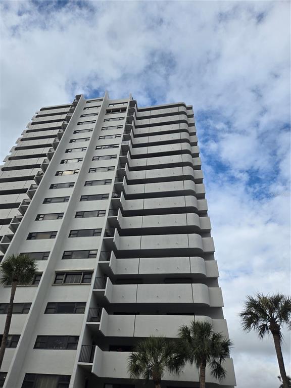 A low-angle view of a tall, white residential high-rise building with stacked balconies — 4141 BAYSHORE BOULEVARD S UNIT 1502, TAMPA, FL