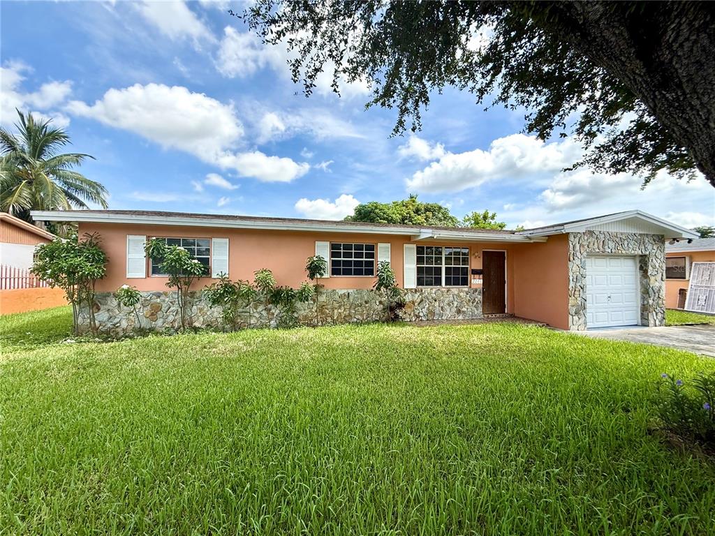 A single-story house with a peach-colored exterior, stone facade, and an attached garage — 2241 NW 190TH TERRACE, MIAMI GARDENS, FL