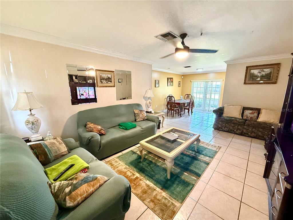 A living room features tile flooring, two sofas, a coffee table, and a dining area — 2241 NW 190TH TERRACE, MIAMI GARDENS, FL