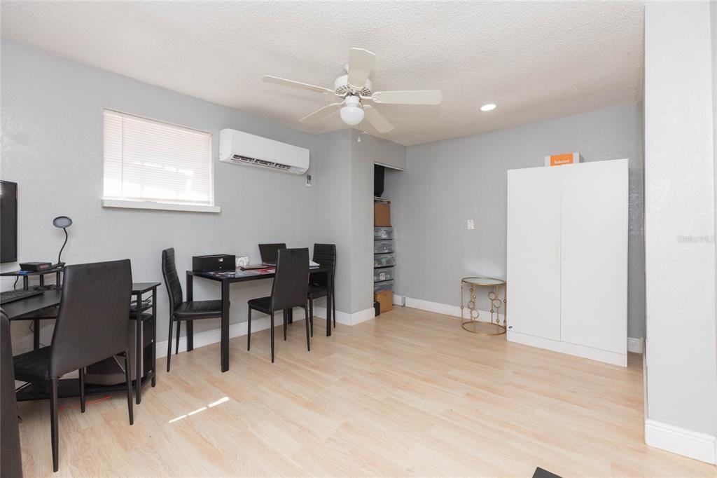 A room with light wood flooring, a ceiling fan, a dining set, and a white wardrobe — 1526 CLINTON, TAMPA, FL