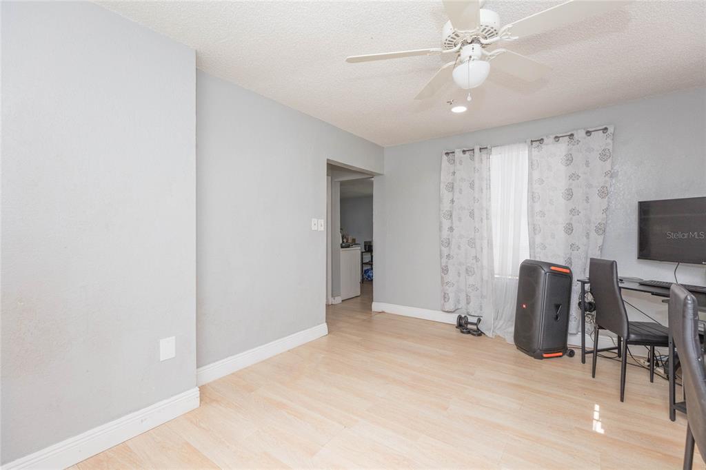 A room with light wood-look flooring, gray walls, a ceiling fan, and a window — 1526 CLINTON, TAMPA, FL