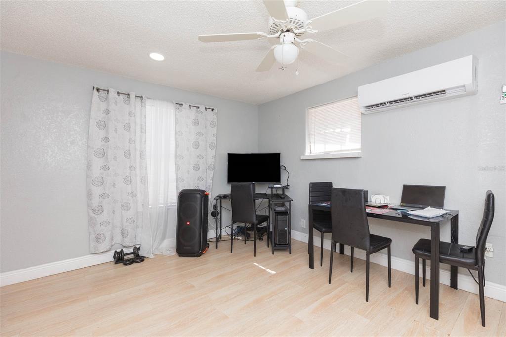 A room with light wood flooring, a ceiling fan, a desk, and a dining set — 1526 CLINTON, TAMPA, FL