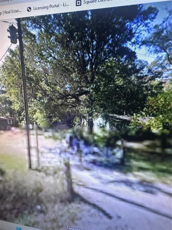 A view of a residential property exterior featuring a utility pole and mature trees — 2180 BONIFAY GRITNEY ROAD, CARYVILLE, FL