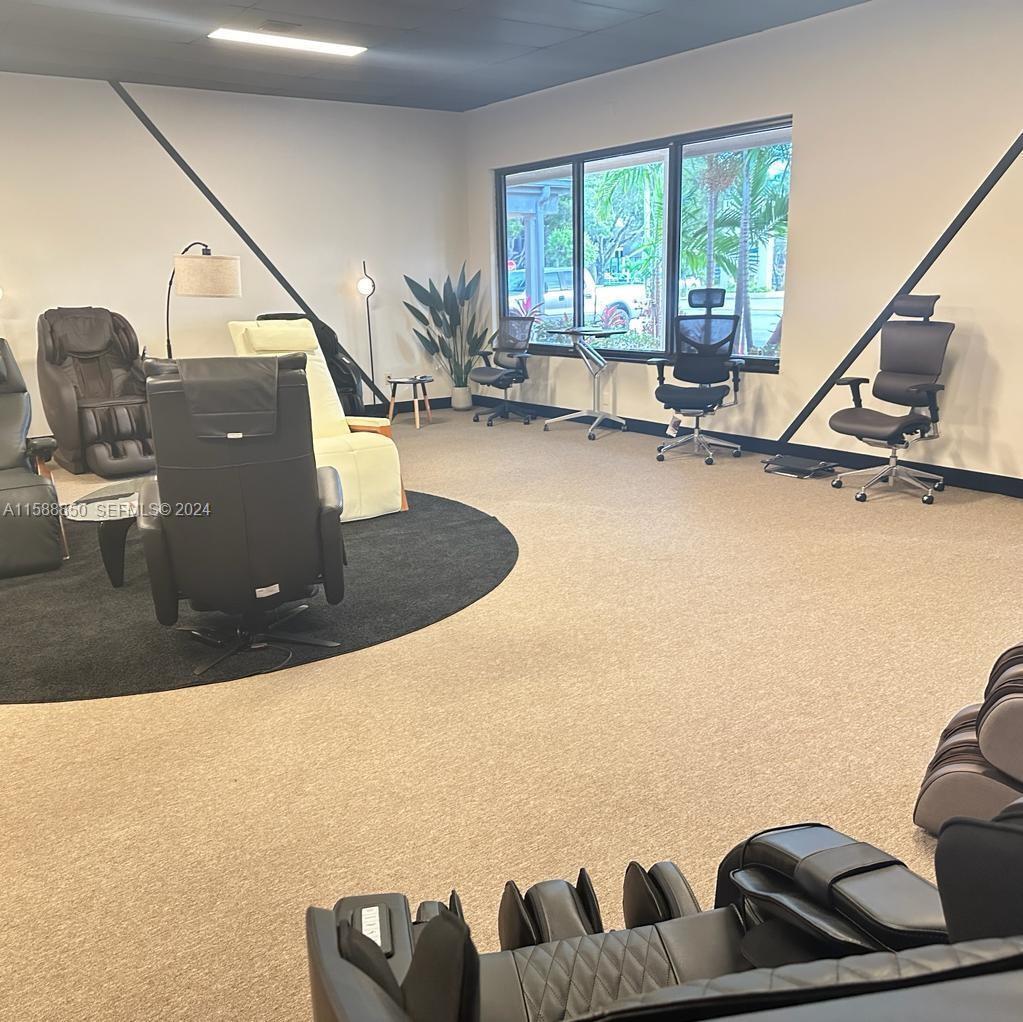 A showroom features various massage chairs, office chairs, and a round rug on carpet — 4301 N Federal Highway # 4, Pompano Beach FL 33064, POMPANO BEACH, FL