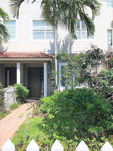 The exterior of a multi-story townhouse features a brick walkway, palm trees, and landscaping — 118 Ocean Cay Way, Hypoluxo FL 33462, HYPOLUXO, FL