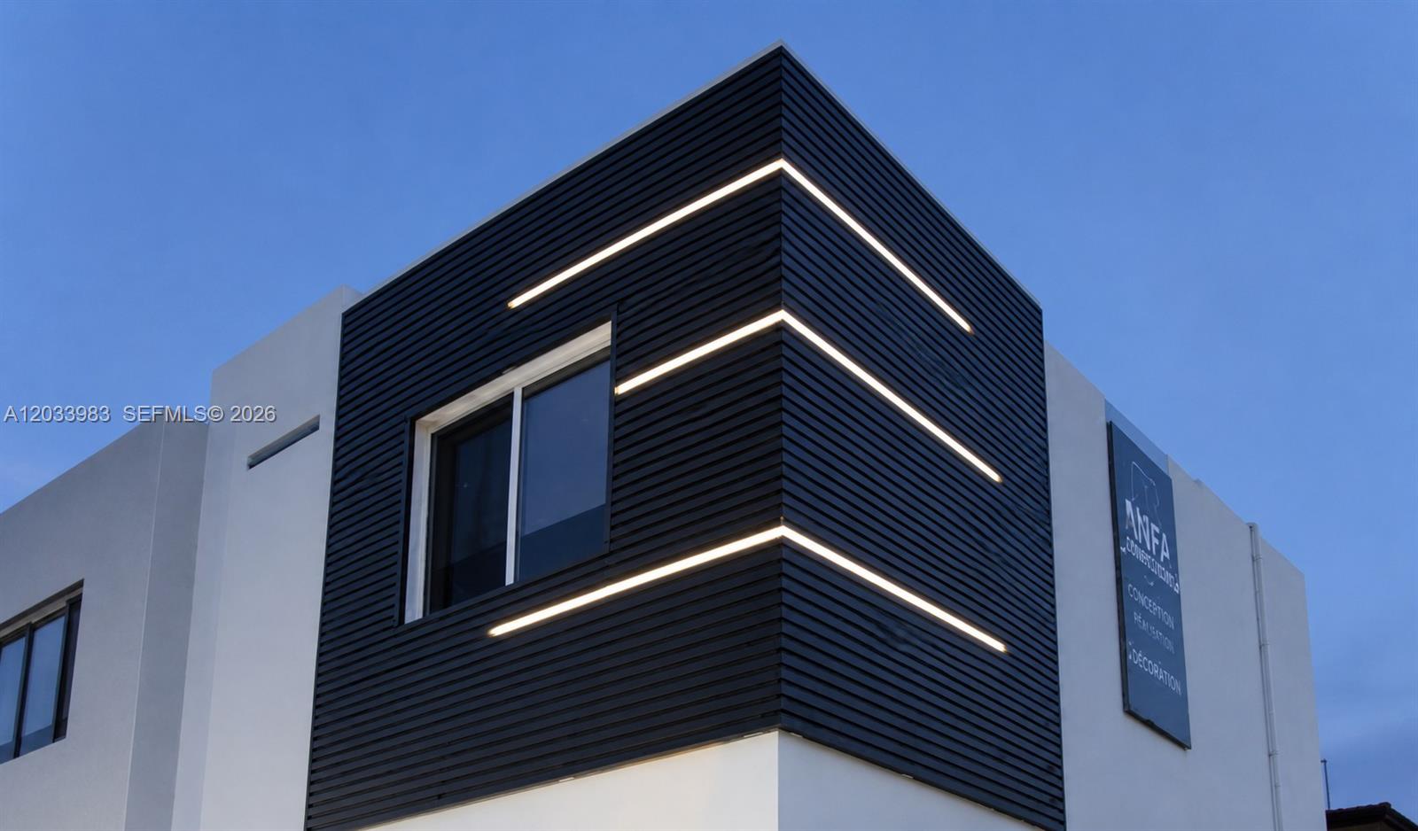 A modern building exterior features black horizontal siding with integrated linear lighting on a corner — 171 NW 158th St # 10, Miami FL 33169, MIAMI, FL