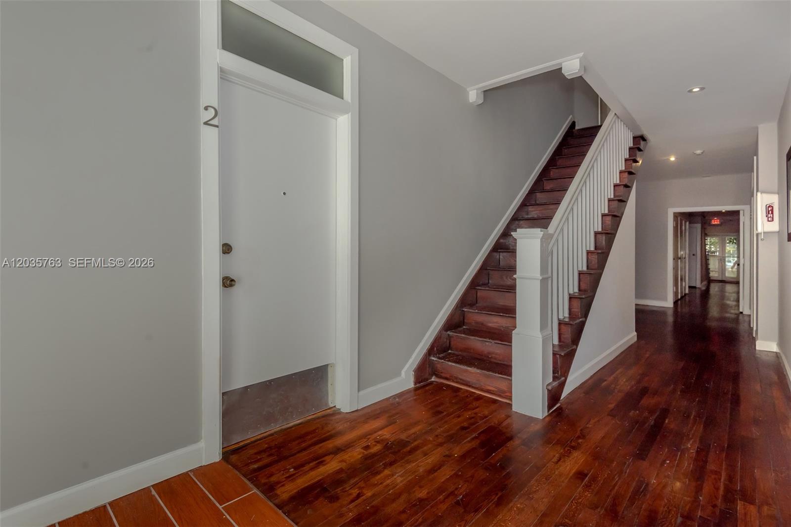 A hallway features a white door labeled 2, a wooden staircase, and hardwood flooring — 1610 Salzedo St # 5, Coral Gables FL 33134, CORAL GABLES, FL