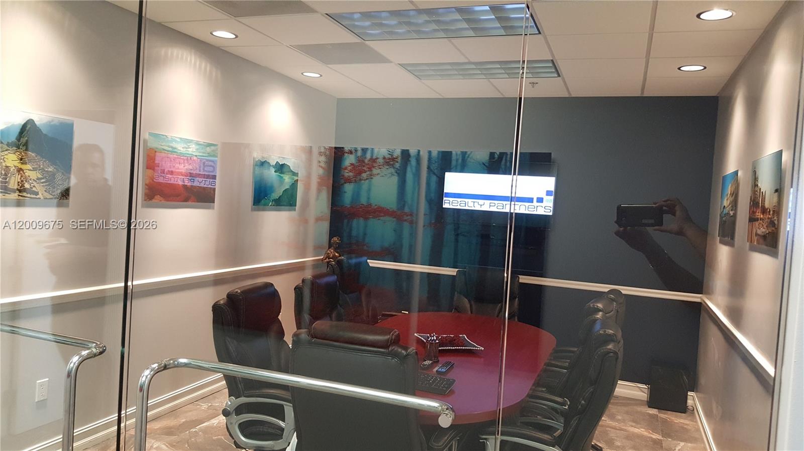A glass-enclosed conference room features a red oval table, leather chairs, and wall art — 7500 NW 25th St # 114, Miami FL 33122, MIAMI, FL