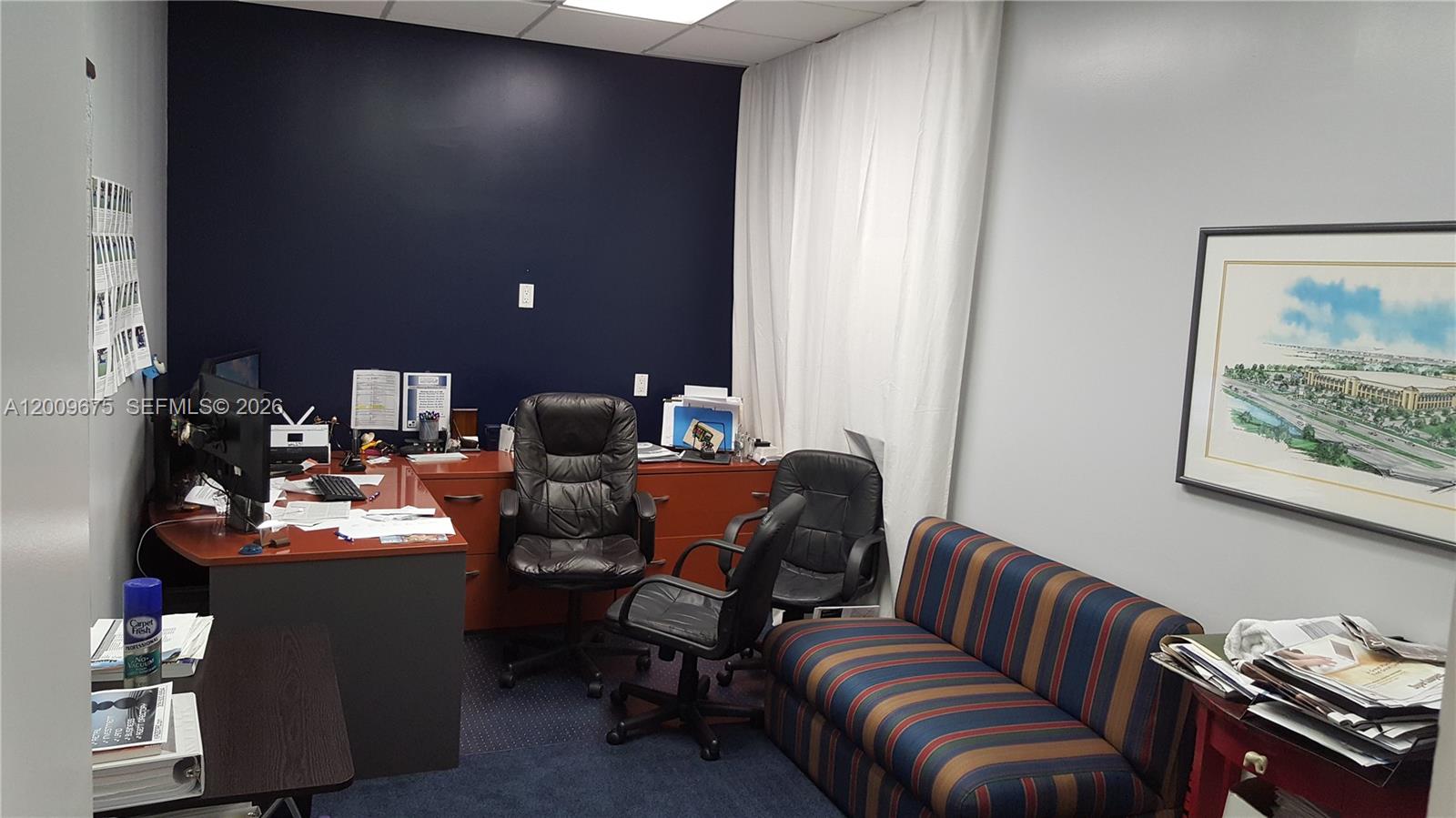 An office features a desk, two chairs, a striped sofa, and a framed wall print — 7500 NW 25th St # 114, Miami FL 33122, MIAMI, FL