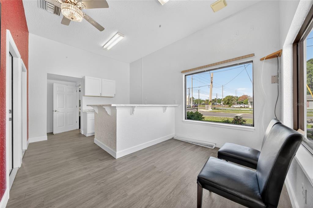 A room with gray wood-look flooring, a white service counter, and two black chairs — 595 9TH STREET, WINTER GARDEN, FL