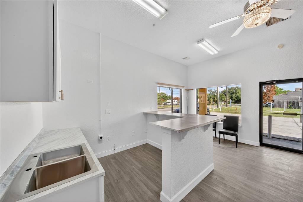 A commercial space featuring a kitchenette with a sink, a service counter, and large windows — 595 9TH STREET, WINTER GARDEN, FL