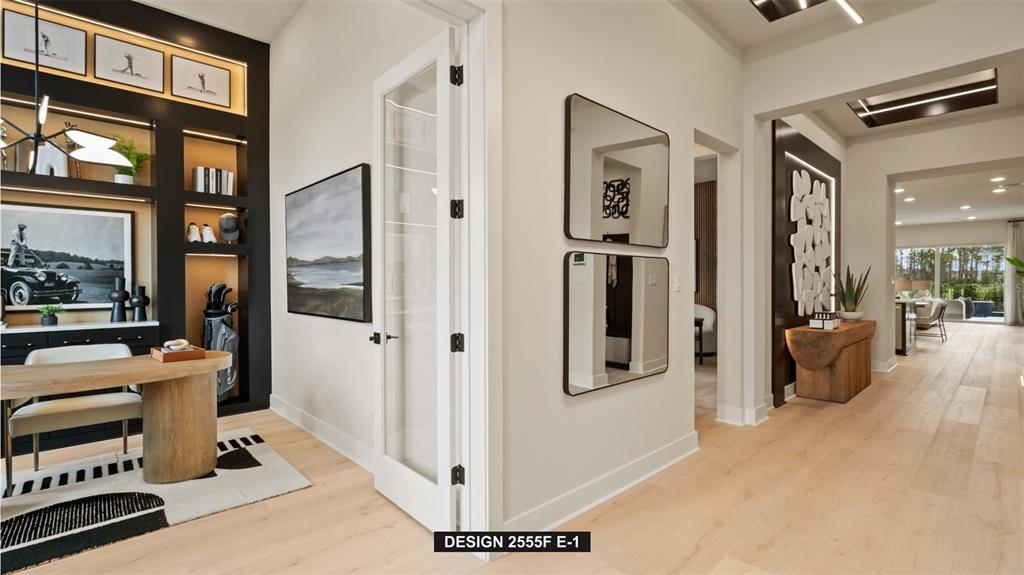 A modern home office with built-in shelving and a glass door opens to a hallway — 314 HOLLY BANK AVENUE, NOKOMIS, FL