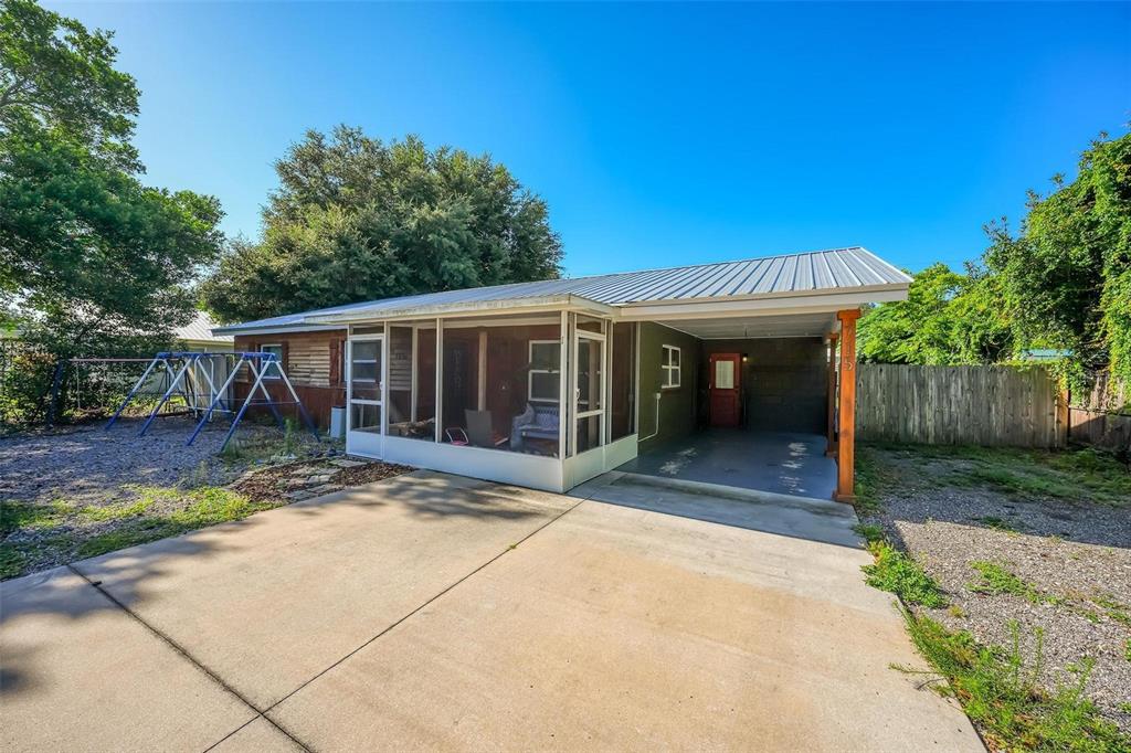 A house exterior features a screened-in porch, a concrete driveway, and an attached carport — 715 4TH STREET, POLK CITY, FL