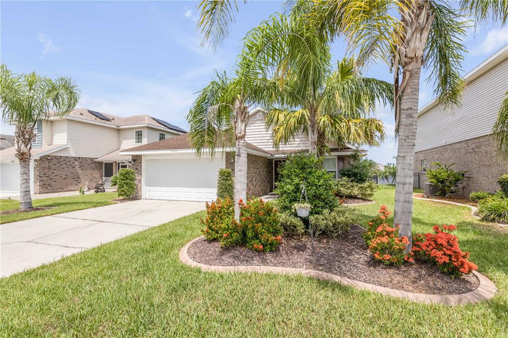A single-story house with a brick facade, a two-car garage, and palm trees in front — 5410 CORDGRASS BEND LANE, PORT ORANGE, FL