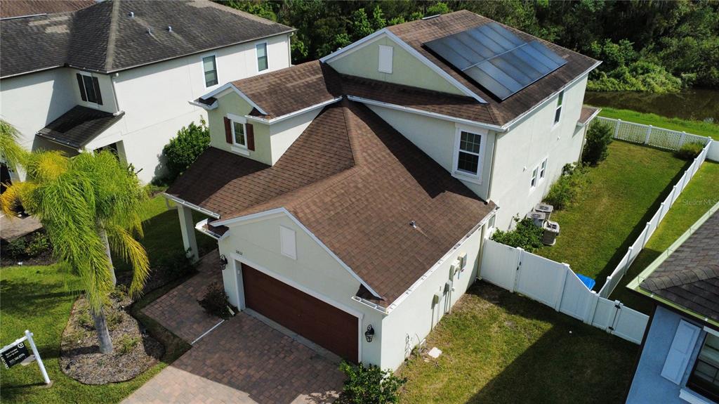 An aerial view of a two-story house with a brown shingled roof and solar panels — 11832 LAKE BOULEVARD, NEW PORT RICHEY, FL