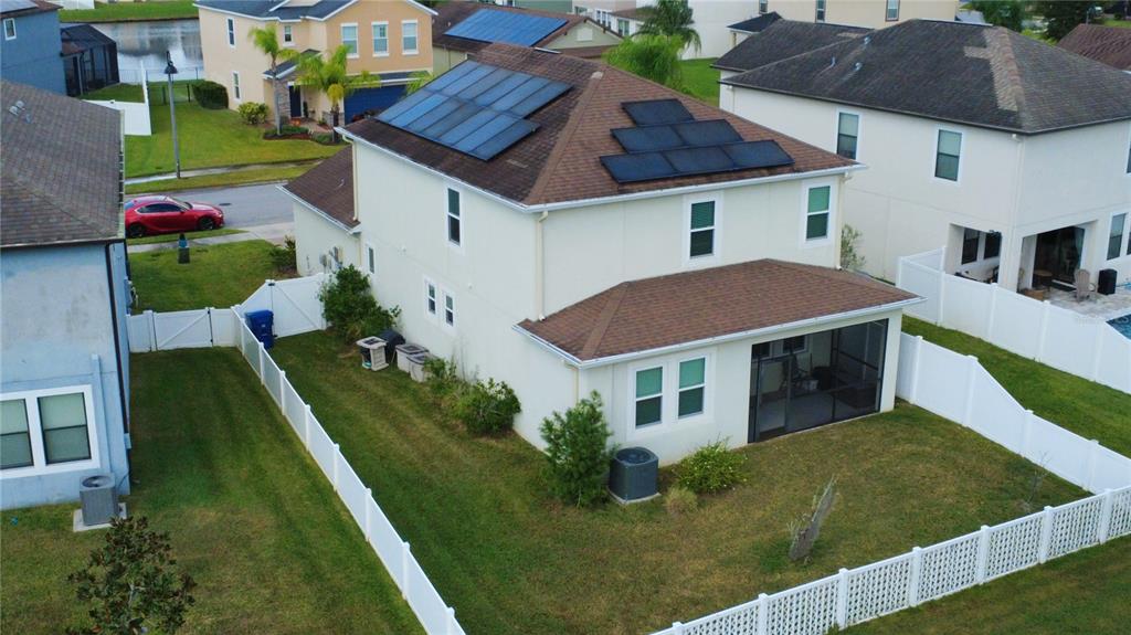 An aerial view of a two-story suburban house with solar panels on the roof — 11832 LAKE BOULEVARD, NEW PORT RICHEY, FL