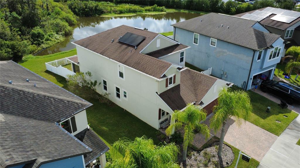 An aerial view shows a two-story house with a brown roof and solar panels — 11832 LAKE BOULEVARD, NEW PORT RICHEY, FL