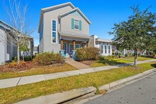 A two-story house with light-colored siding, a front porch, and a sidewalk in front — 12837 SALK WAY, ORLANDO, FL