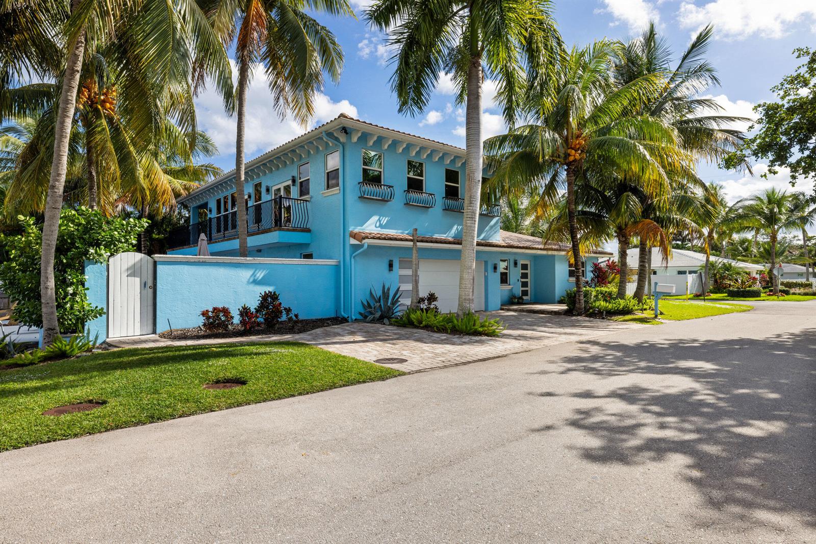 A bright blue two-story house with a white garage and palm trees in the front — 100 Neptune Drive, Hypoluxo FL 33462, HYPOLUXO, FL