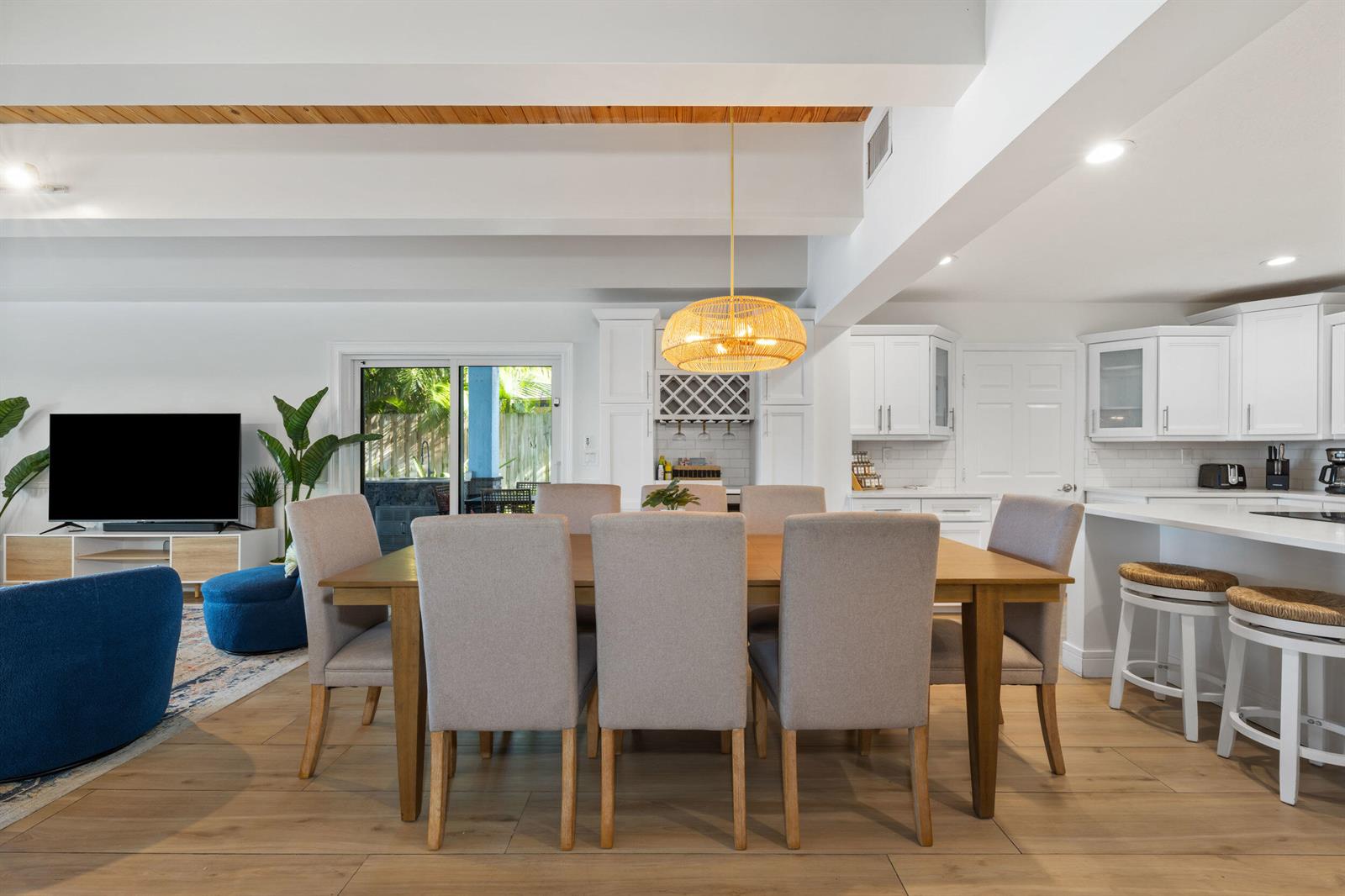 A dining area with a wooden table and chairs sits in an open-concept living space — 100 Neptune Drive, Hypoluxo FL 33462, HYPOLUXO, FL