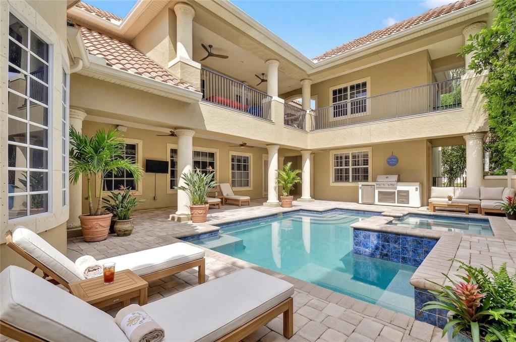 A two-story house with a courtyard featuring a swimming pool, spa, and patio furniture — 11226 MACAW COURT, WINDERMERE, FL