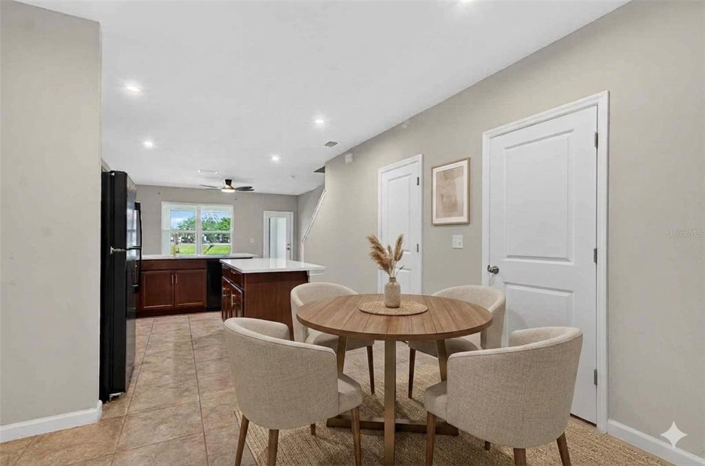 A dining area with a round wooden table and four chairs sits near a kitchen — 3048 VICTORIA INLET DRIVE, HOLIDAY, FL