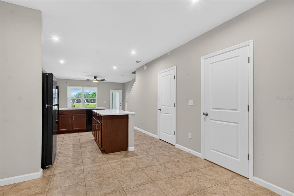 A kitchen features dark wood cabinets, a center island, and tile flooring — 3048 VICTORIA INLET DRIVE, HOLIDAY, FL