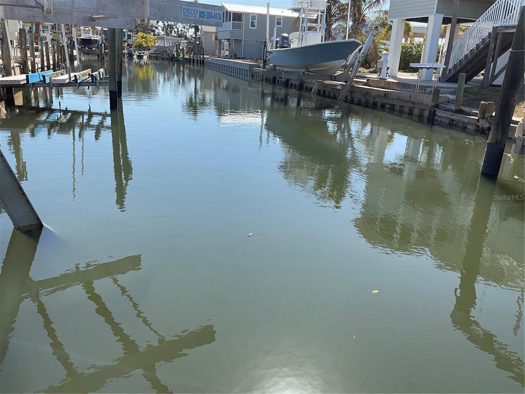 A canal view showing boat lifts, docks, and residential homes along the waterfront — 165 MORNING STAR ROAD, VENICE, FL