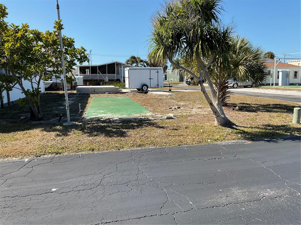 A vacant lot features a green concrete pad, a white trailer, and two palm trees — 165 MORNING STAR ROAD, VENICE, FL