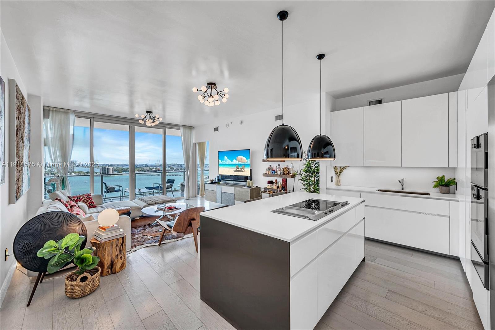 A modern open-concept kitchen and living area features a center island and floor-to-ceiling windows — 2020 N Bayshore Dr # 1906, Miami FL 33137, MIAMI, FL