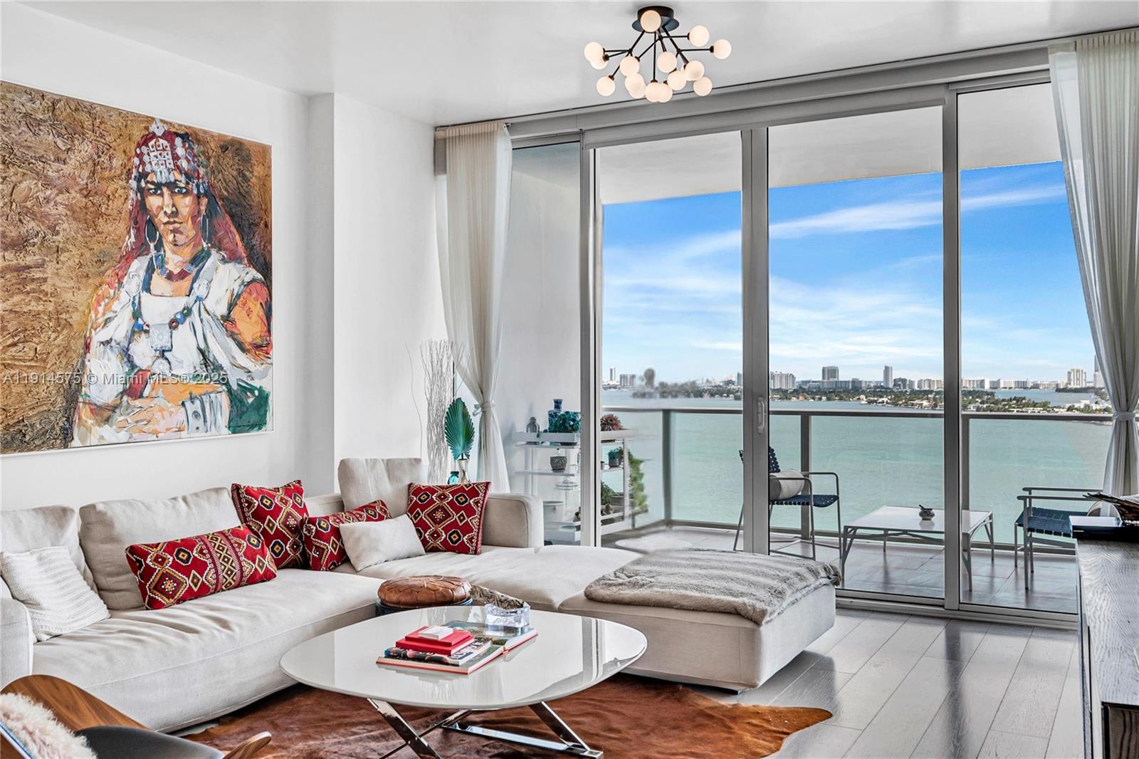 A living room with a large sectional sofa, a coffee table, and a balcony view — 2020 N Bayshore Dr # 1906, Miami FL 33137, MIAMI, FL