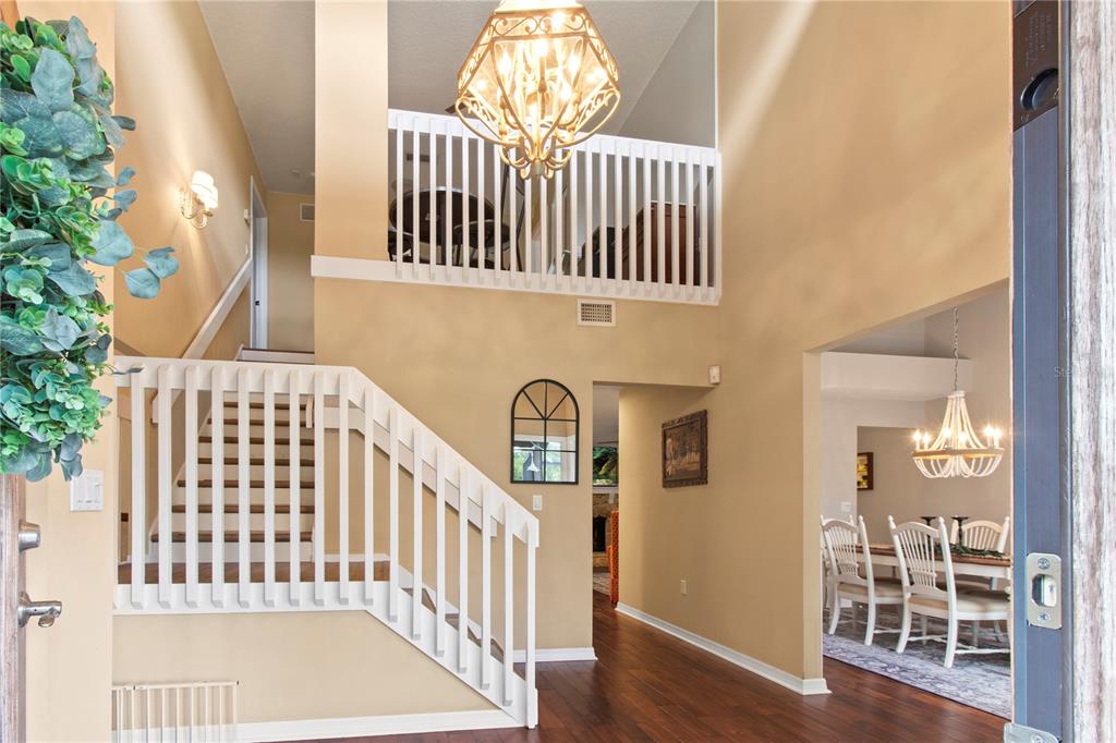 An entryway with a staircase, a chandelier, and a view into a dining room — 1279 CORNISH COURT, SARASOTA, FL