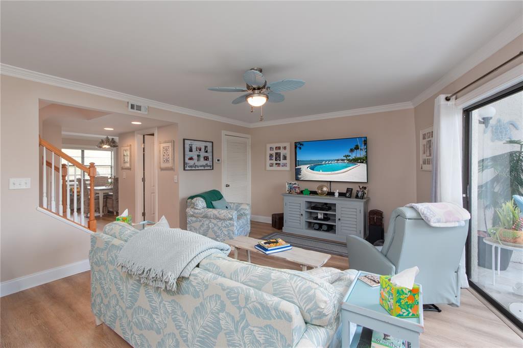 A living room features a patterned sofa, a light blue recliner, and a television console — 15 TURNER STREET UNIT 4, CLEARWATER, FL