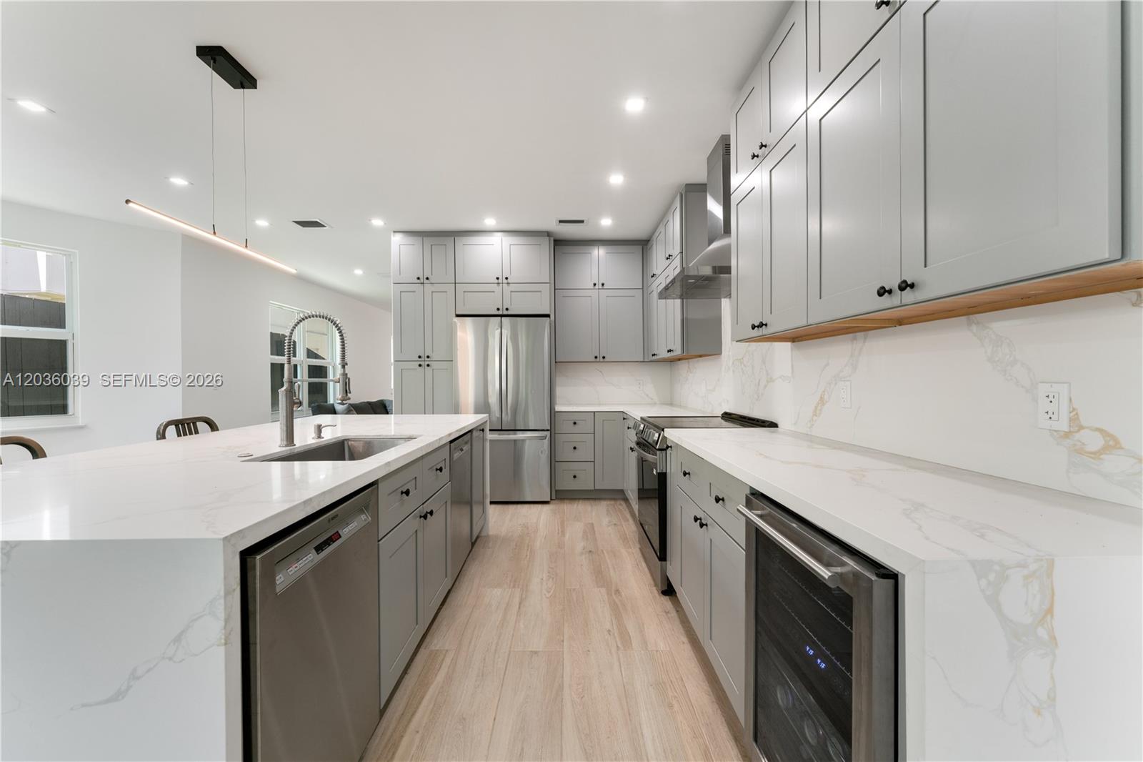A modern kitchen features gray cabinets, white marble countertops, and stainless steel appliances — 3125 Paola Dr # 15, Miami FL 33133, MIAMI, FL