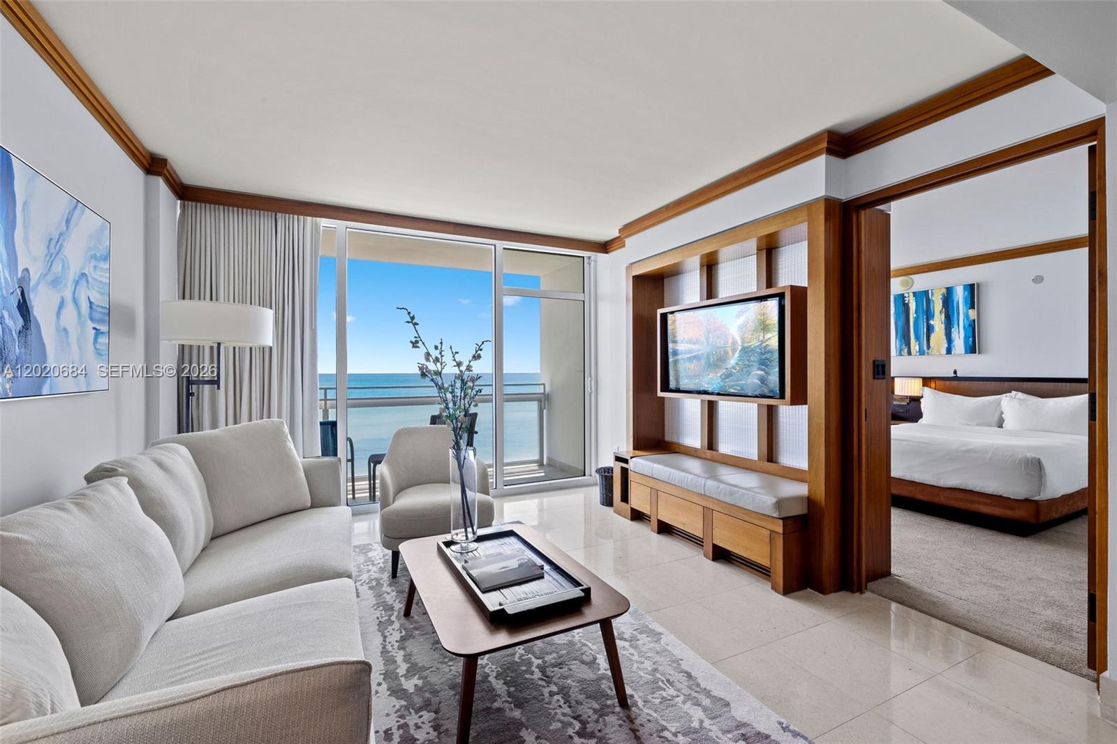 A living room with a sofa, coffee table, and television unit opens to a bedroom — 6801 Collins Ave # 417, Miami Beach FL 33141, MIAMI BEACH, FL