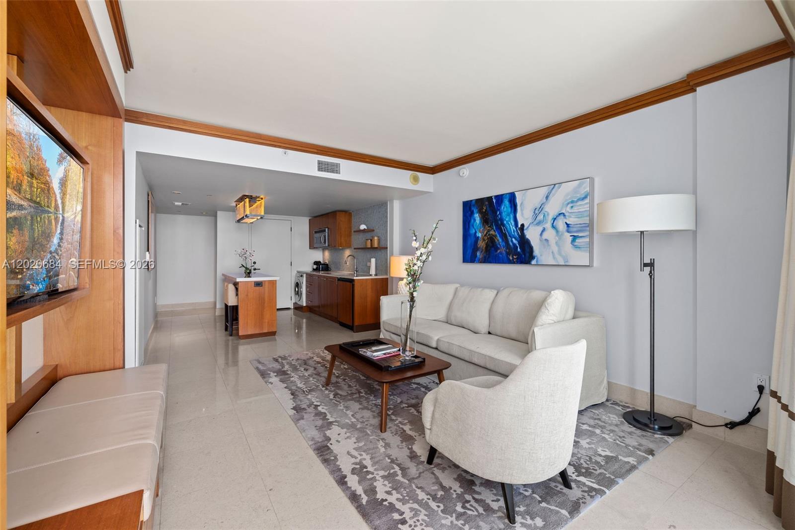 A living room features a sofa, armchair, coffee table, and an adjacent open-concept kitchen — 6801 Collins Ave # 417, Miami Beach FL 33141, MIAMI BEACH, FL