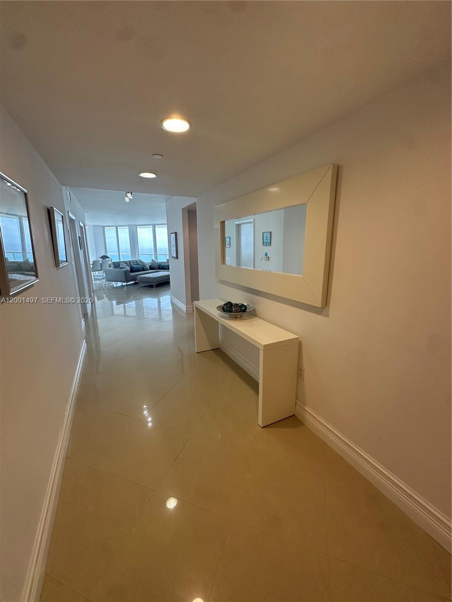A hallway with beige tile floors leads to a living area with ocean views — 6365 Collins Ave # 1703, Miami Beach FL 33141, MIAMI BEACH, FL
