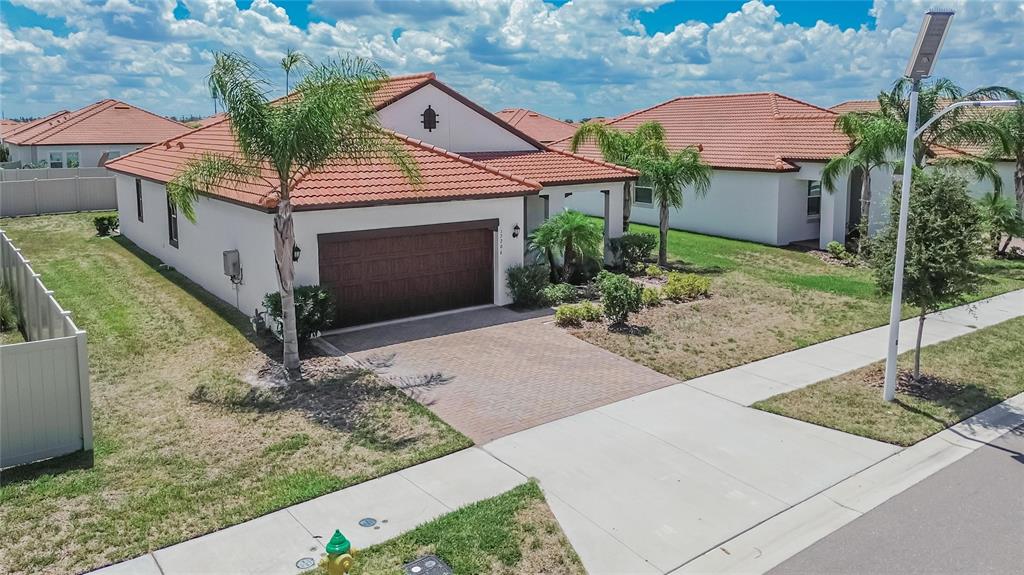 An aerial view of a single-story house with a tile roof, garage, and paved driveway — 17206 STAR BANKS STREET, WIMAUMA, FL
