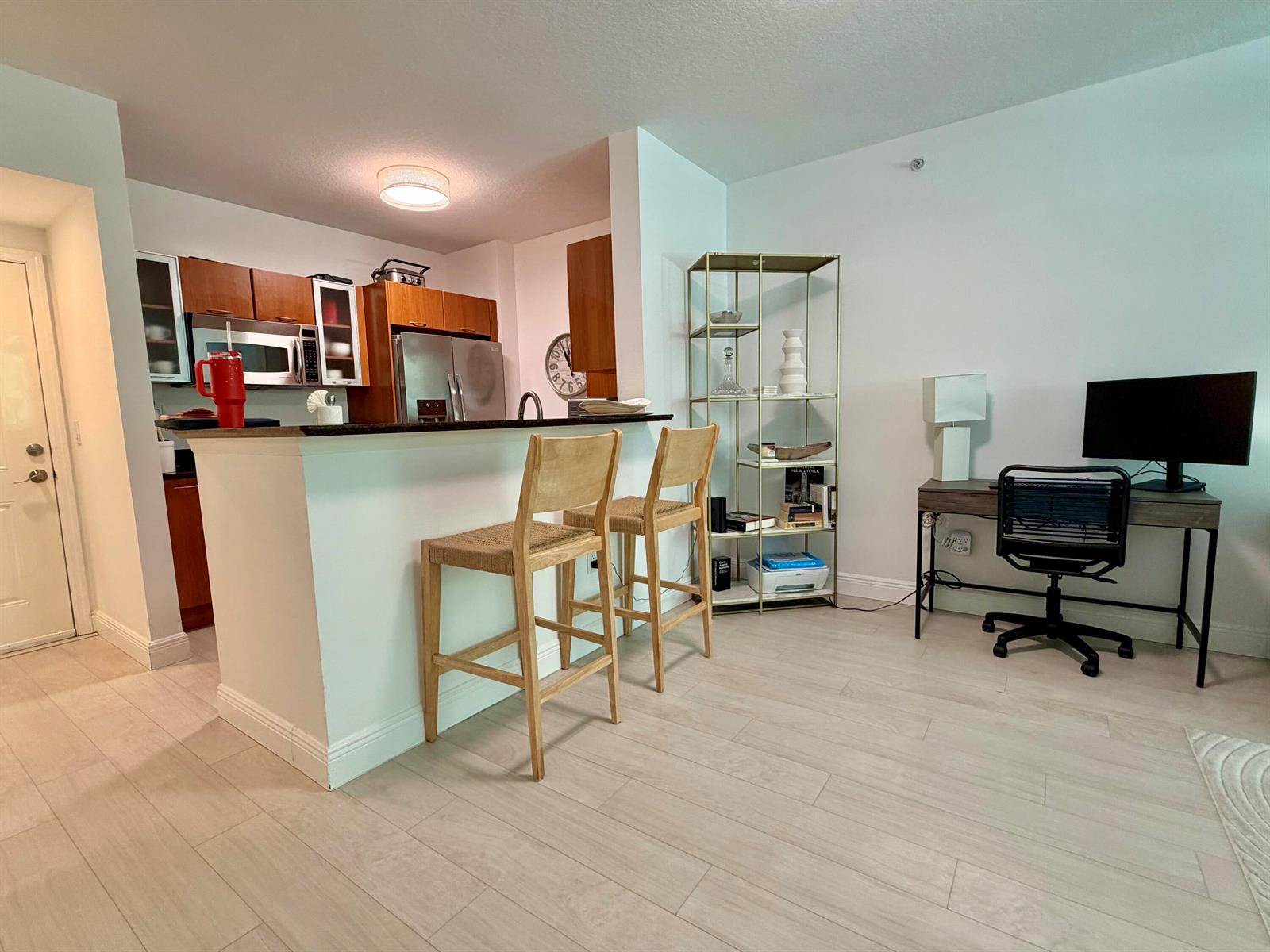 A kitchen with wood cabinets and a breakfast bar next to a home office area — 625 Casa Loma Boulevard # 207, Boynton Beach FL 33435, BOYNTON BEACH, FL