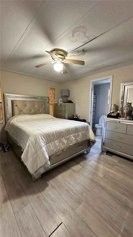 A bedroom with a bed, dresser, ceiling fan, and a visible water stain on the ceiling — 4422 ROSE STREET, VALRICO, FL